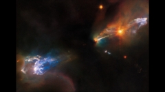 Newborn twin stars blast out jets of rainbow-colored gas in brand-new Hubble image