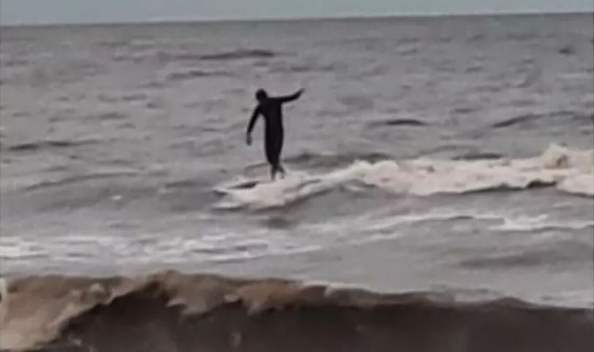 Stunning minute internet user is spotted riding big waves in Storm Babet